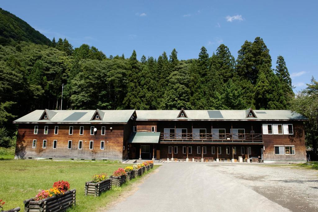 津南町小鹿百合之宿旅馆的一座大型砖砌建筑,上面有太阳能电池板