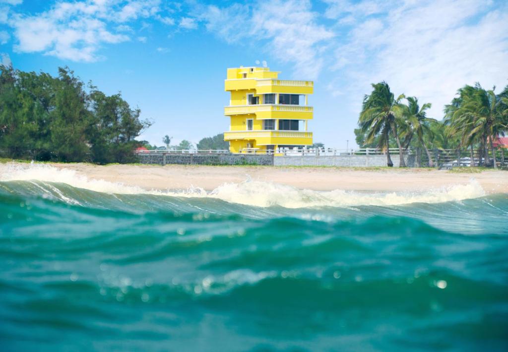 蓬蒂切里Pranaav Beach Resort的海边的黄色建筑