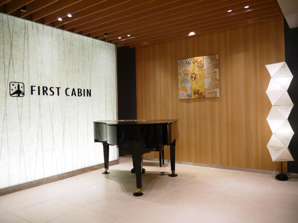 泉佐野First Cabin Kansai Airport的钢琴,在房间,有第一个 ⁇ 标志