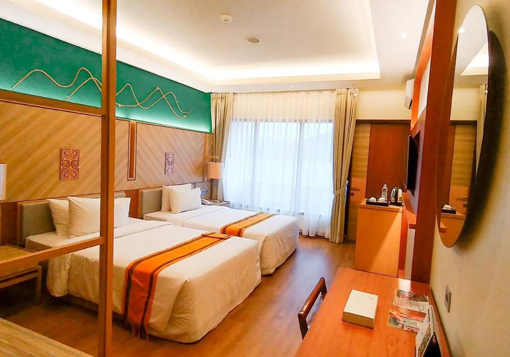 巴拉巴特Khas Parapat的酒店客房设有两张床和一张桌子。