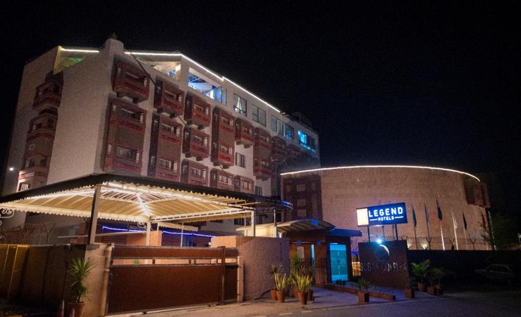 伊斯兰堡Legend Hotel Islamabad的一座建筑,在晚上前有标志