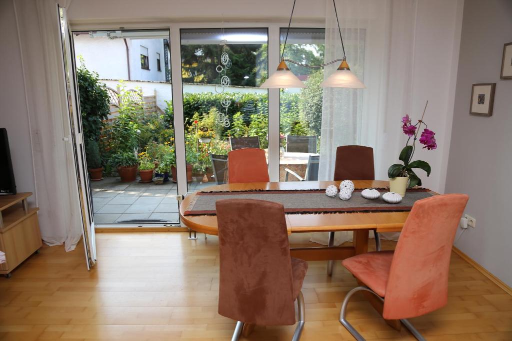 福希海姆FeWo "Regnitztraum" in Forchheim - 3-Zimmer-Apartment - 2 Schlafzimmer的配有木桌和橙色椅子的用餐室