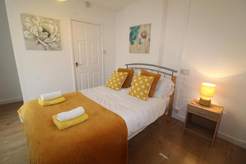 德比Winslow Green House的一间卧室配有一张带黄色枕头的床。