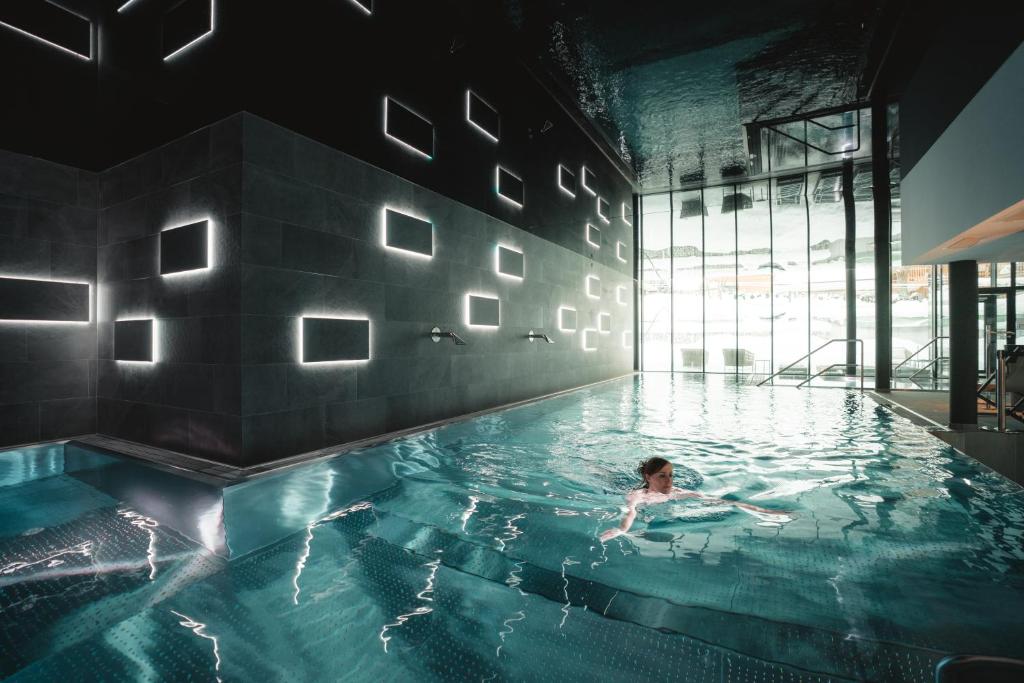 采尔马特Alpen Resort & Spa的在游泳池游泳的人