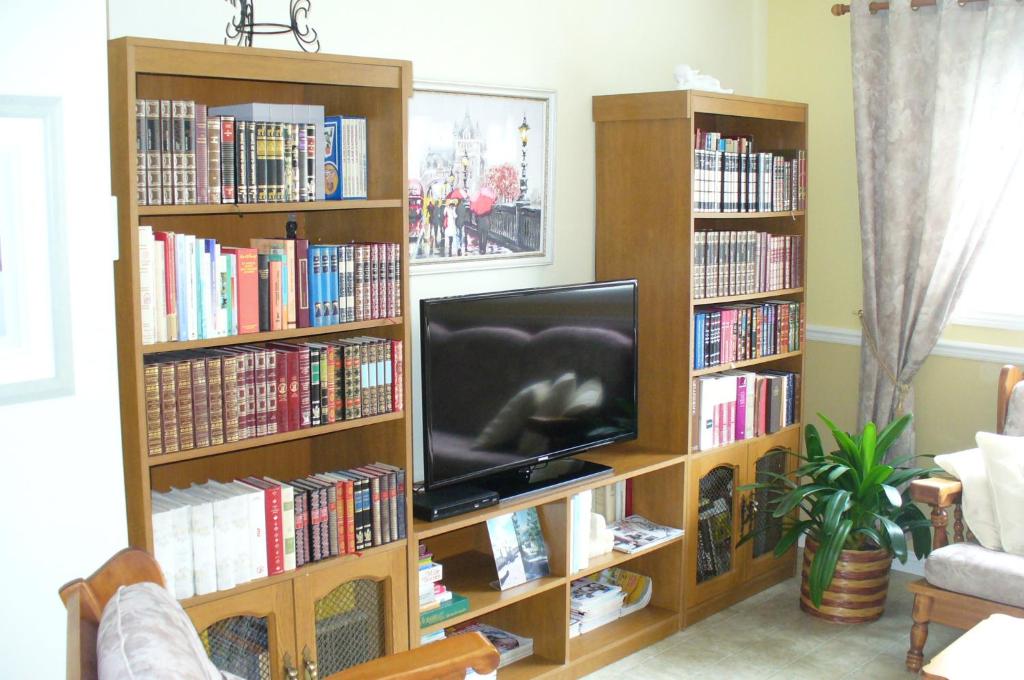 Pabos吉特香水海住宿加早餐酒店的客厅配有书架,书架上装满了书籍
