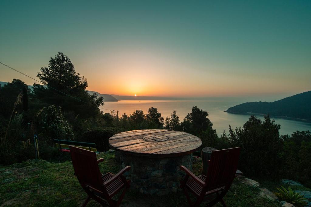 坎普码头La Collina sul Mare的一张桌子和两把椅子,背靠日落
