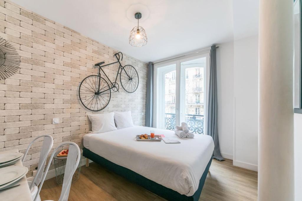 巴黎Apartments WS St Germain - Quartier Latin的卧室配有一张床,墙上挂着自行车