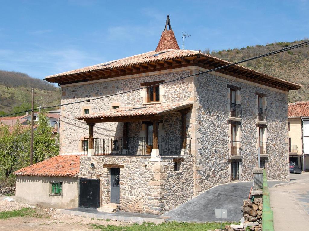 Barbadillo del PezHostal Residencia El Mirador del Pedroso的一座石头建筑,上面有一座塔