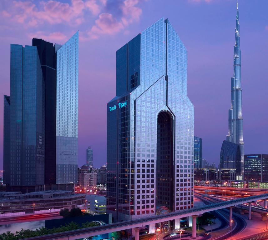 迪拜迪拜杜斯特天阙酒店的城市的一座高大的玻璃建筑