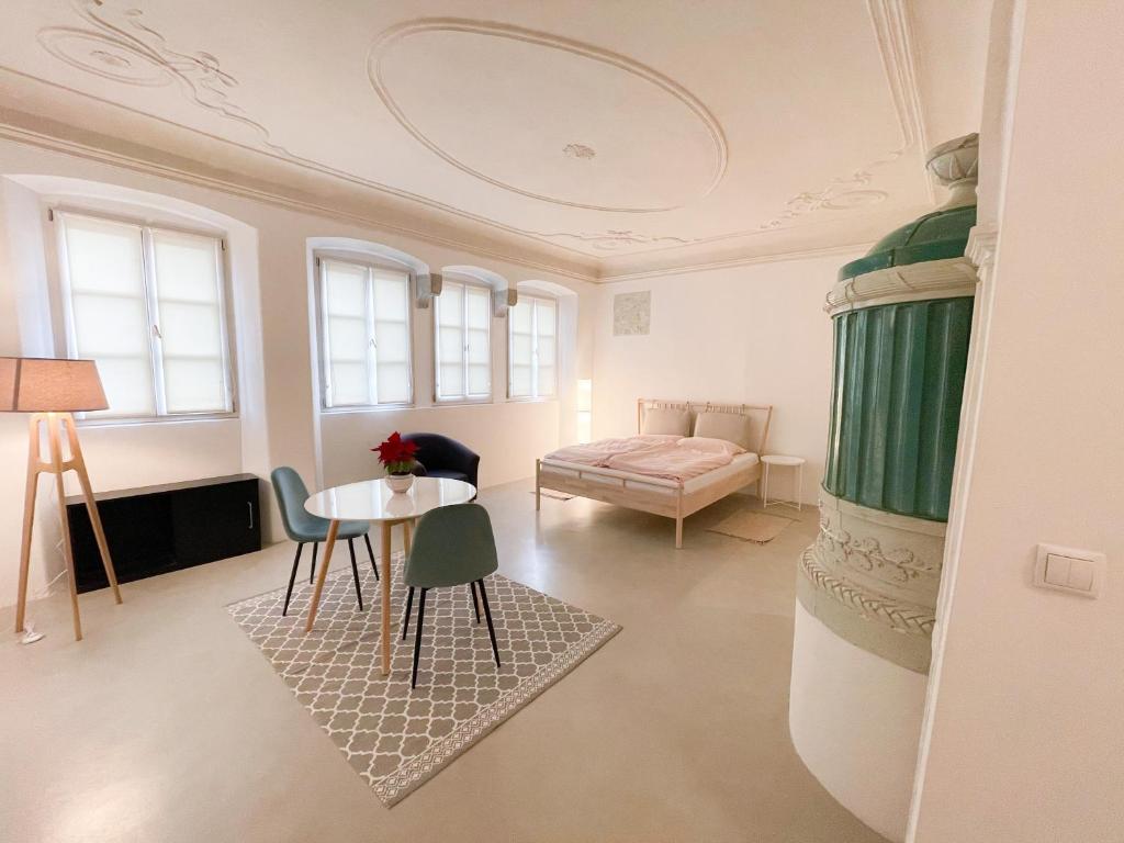 博尔扎诺Lauben Suite Old Town Bolzano的配有一张床和一张桌子及椅子的房间