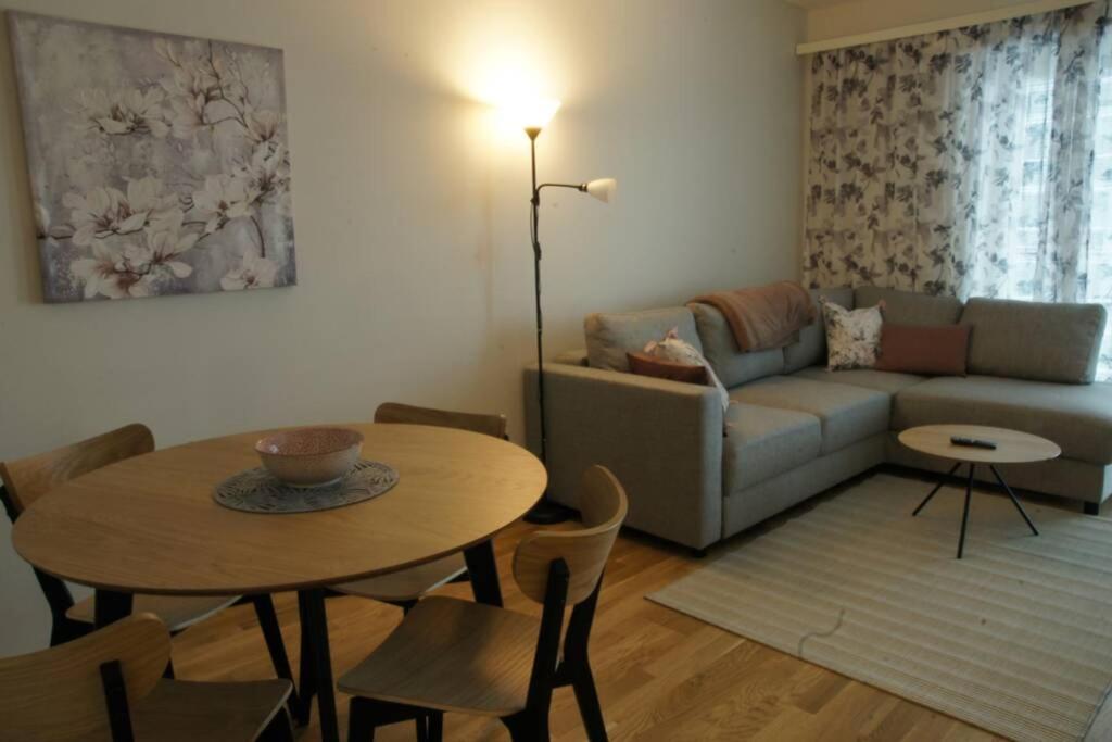 奥卢Keskustan kaksio 45 m2 autopaikalla, Rautatienkatu 19, 9 krs的客厅配有桌子和沙发