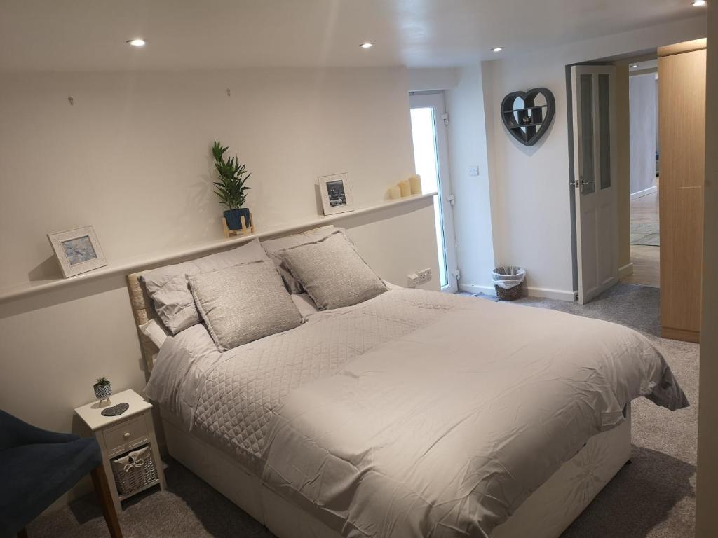 佩恩顿High gables Apartment 1的卧室配有一张带白色床单和枕头的大床。