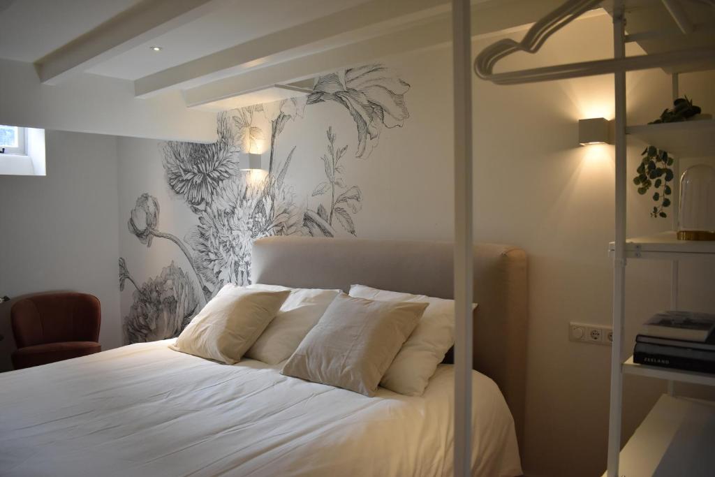 米德尔堡Stadsdromer的一间卧室配有白色床单和热带壁纸。