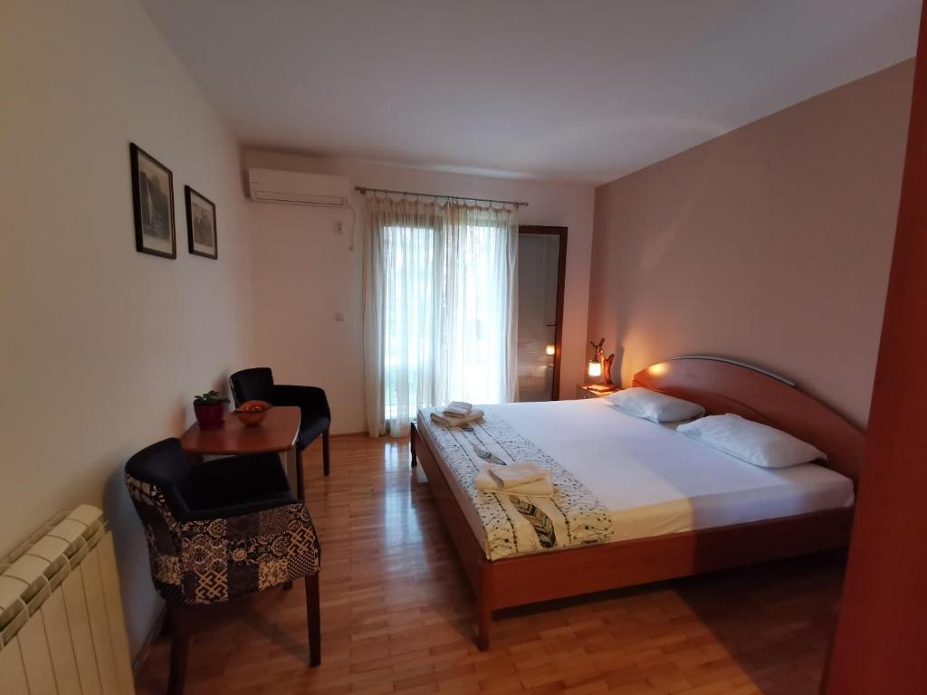威尔帕扎Guesthouse Vukasevic的卧室配有1张床、1张桌子和1把椅子