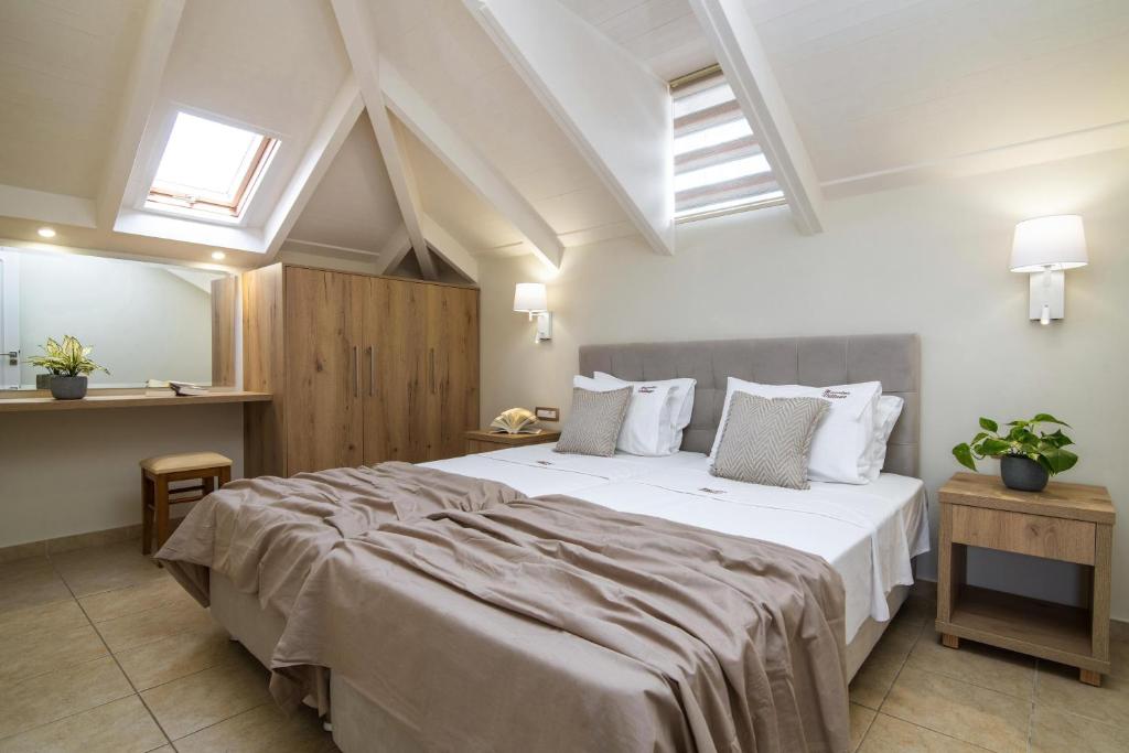 蒂锡利维马夫利亚斯村公寓酒店的卧室配有一张带白色床单和枕头的大床。