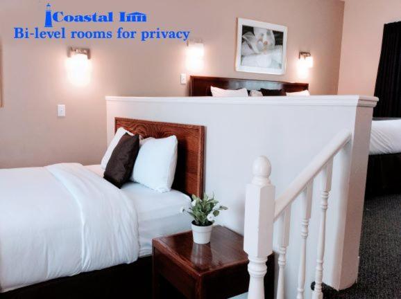 安蒂戈尼什安提格尼斯海岸酒店的卧室配有白色的床和楼梯。
