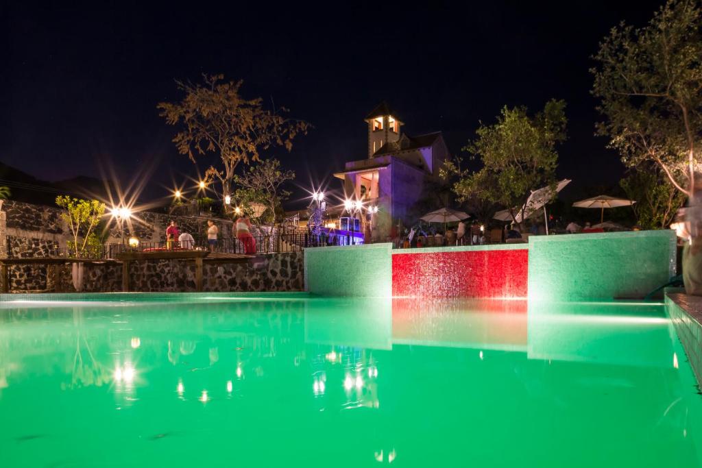 迪坡斯特兰Hotel Boutique Casa Isabella的夜间游泳池,水中灯火通明