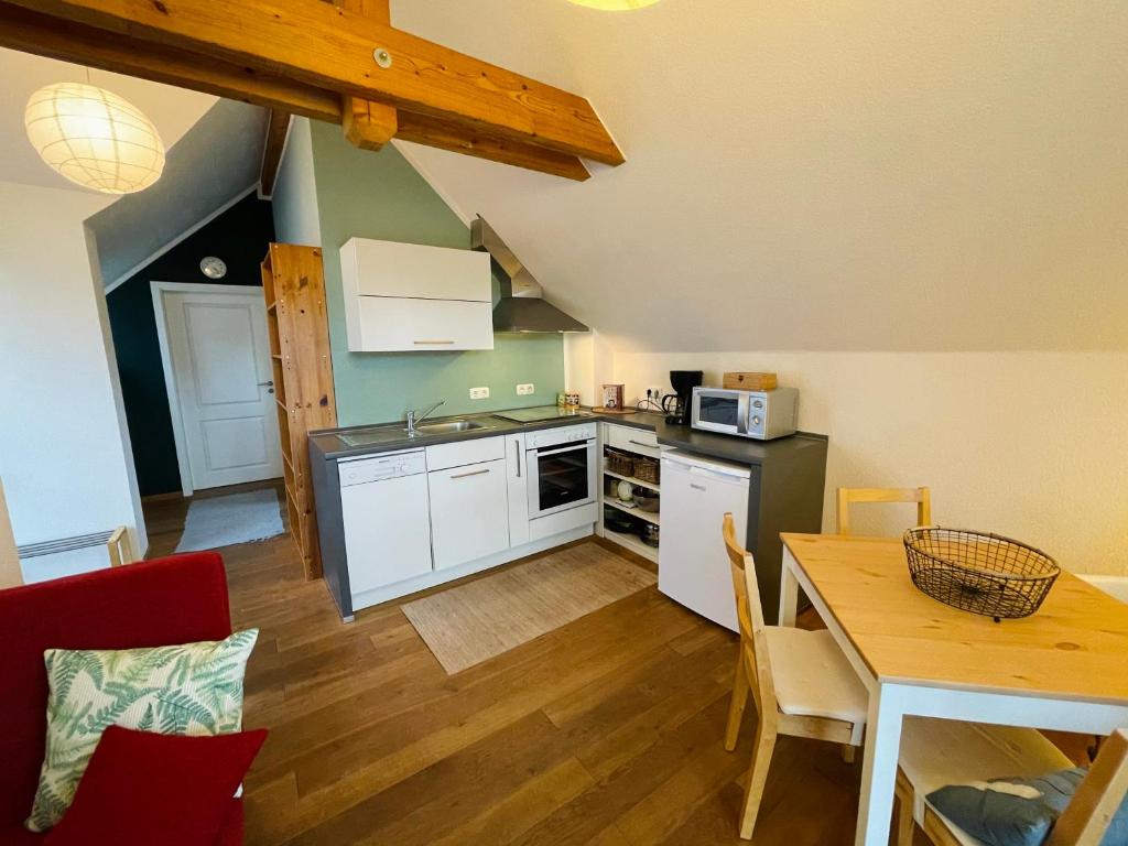 UrbarFerienwohnung „Klein aber fein“的厨房配有白色橱柜、餐桌和用餐室