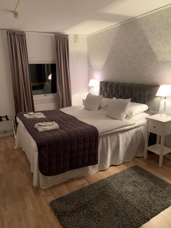 亨尼博斯特兰德Hotell Kaprifol的一间卧室设有一张大床和一个窗户。