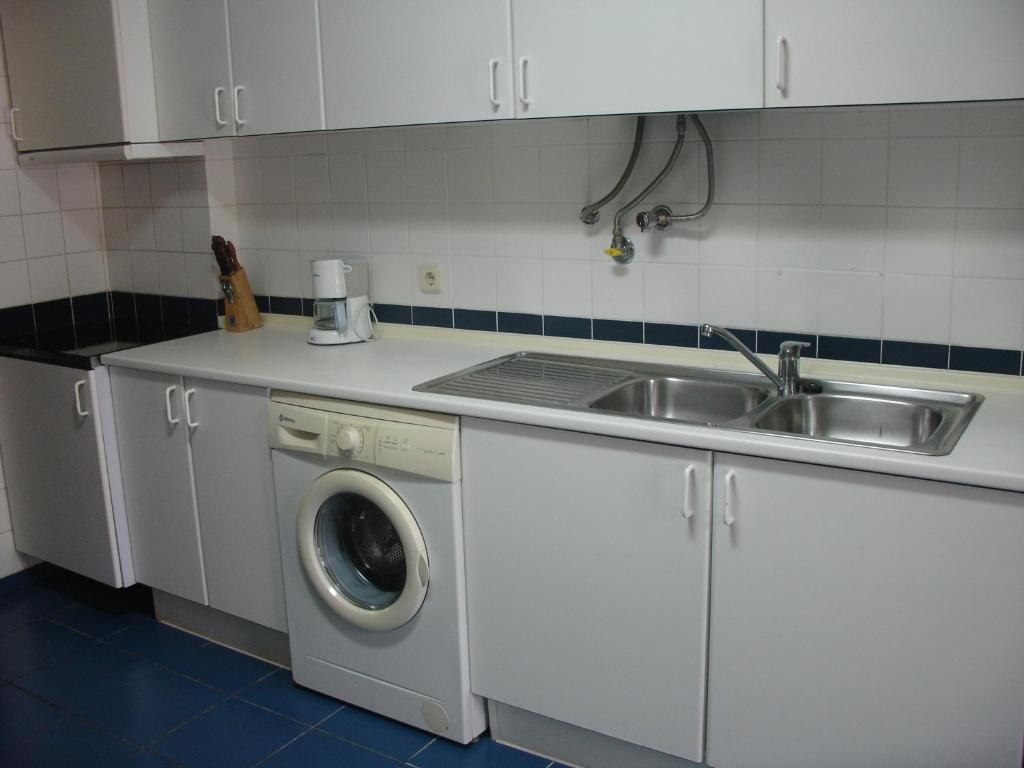 丰沙尔Apartamento Capela的厨房配有水槽和洗衣机