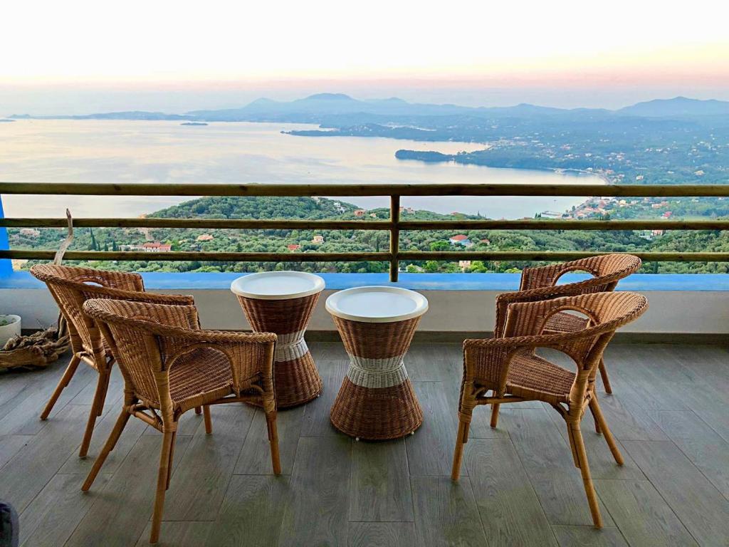 科孚镇House Tanna of Villa Intaba Spectacular Sea Views Corfiot Riviera Spartilas Corfu Island Greece close to Ipsos Beach的美景阳台配有桌椅