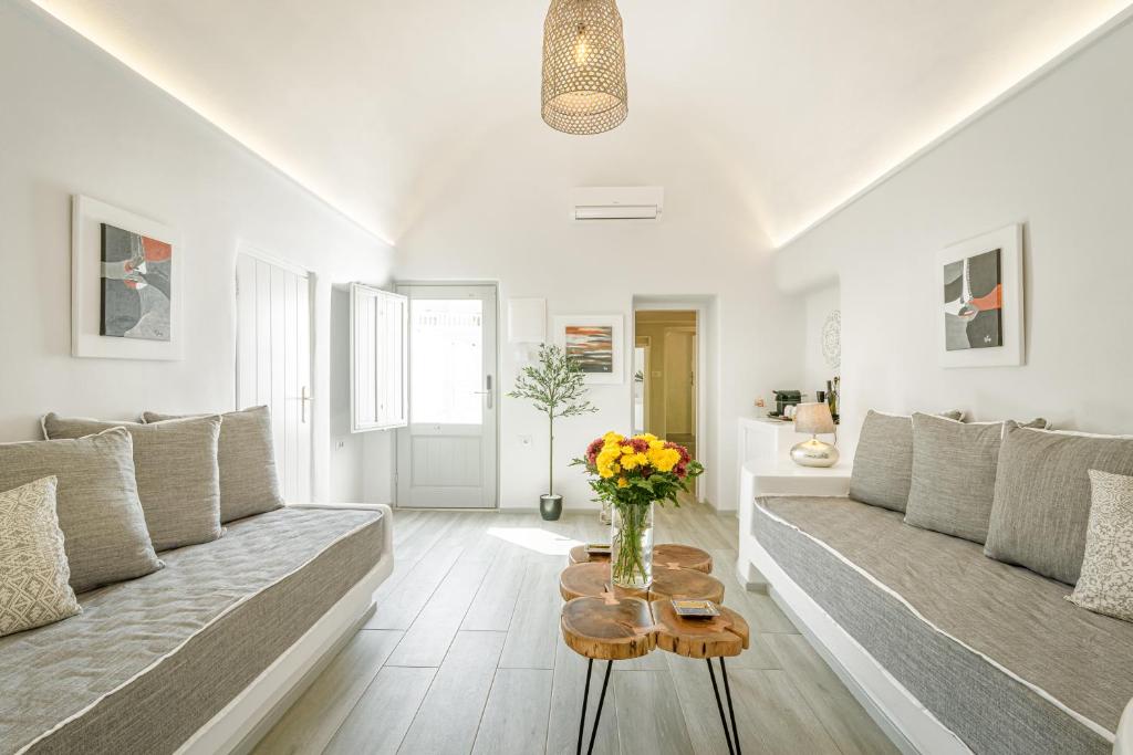 易莫洛林Amoramelia Villas的客厅配有沙发和鲜花桌
