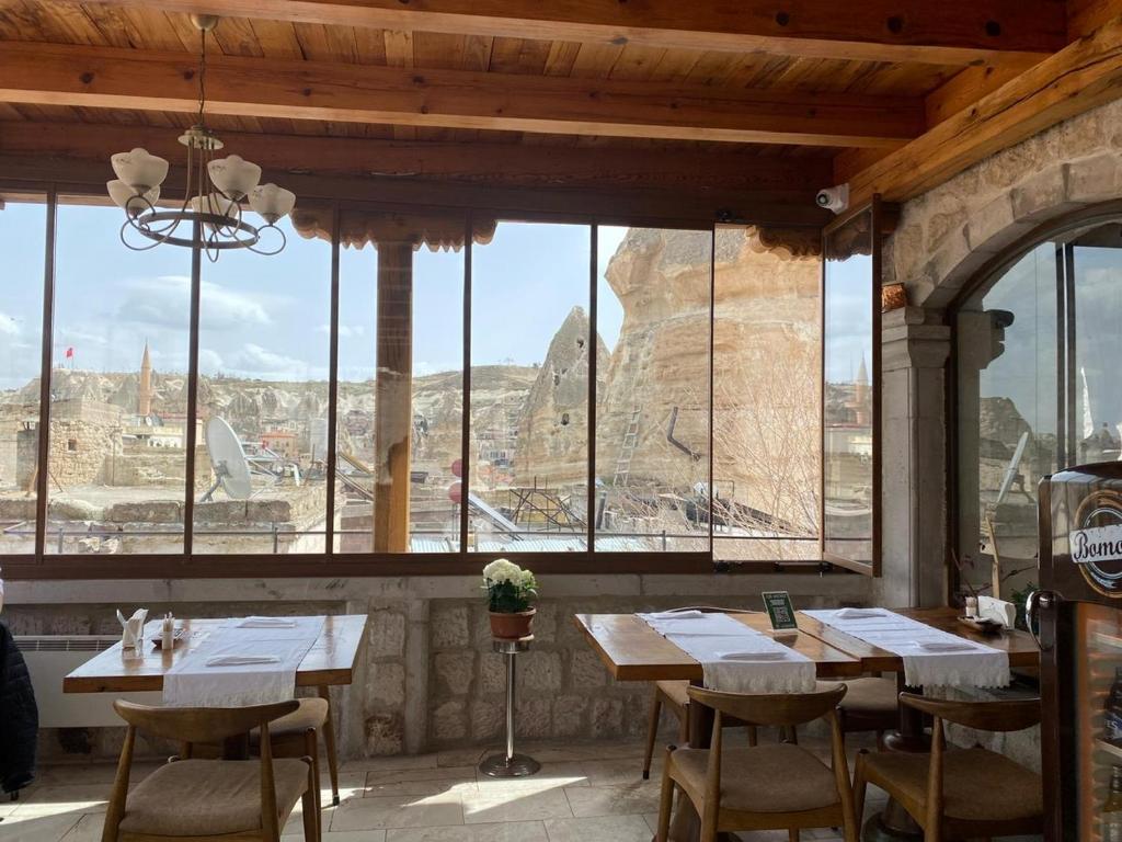 格雷梅阿伊迪尼尔岩洞酒店的餐厅设有木桌和椅子,享有文物美景。
