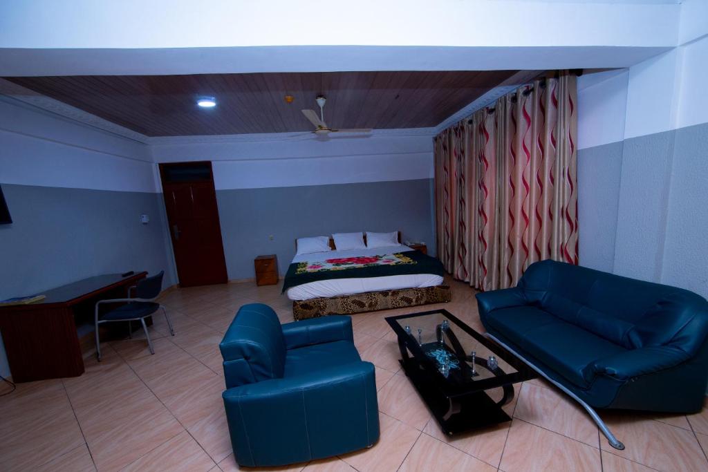 SpintexPemicsa Hotel Accra的客房设有床、沙发和桌子。