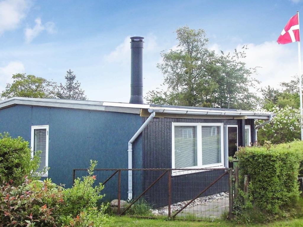 布罗艾厄4 person holiday home in Broager的蓝色的房子,上面有烟 ⁇ 
