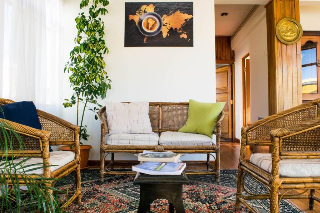 拉巴斯Bright & Comfy Guest House in La Paz的客厅配有藤椅和沙发