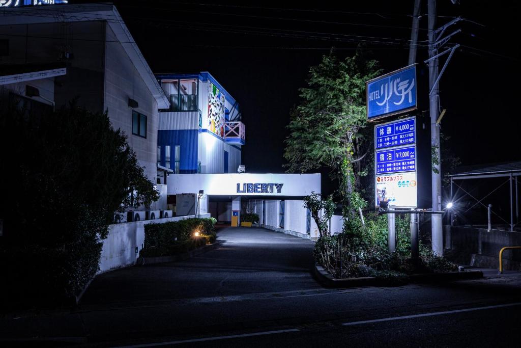 松山松山自由酒店（仅限成人） 的夜间有灯号的建筑物