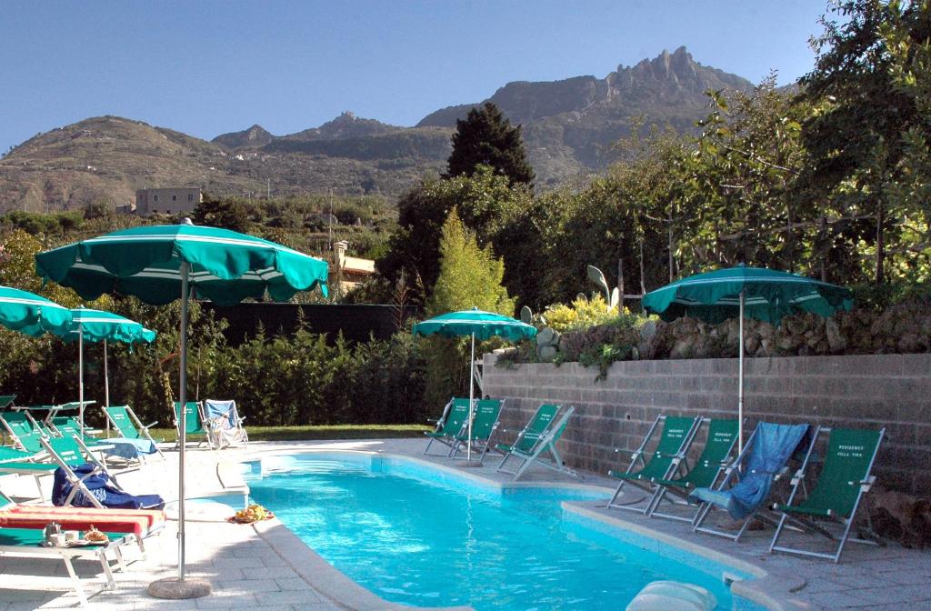 伊斯基亚蒂娜公寓别墅酒店的一个带草坪椅和遮阳伞的游泳池