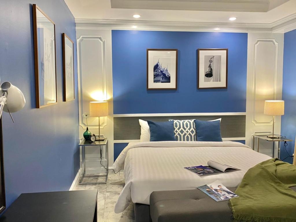 曼谷UHG阿索克素坤逸酒店的一间拥有蓝色墙壁和一张大床的卧室