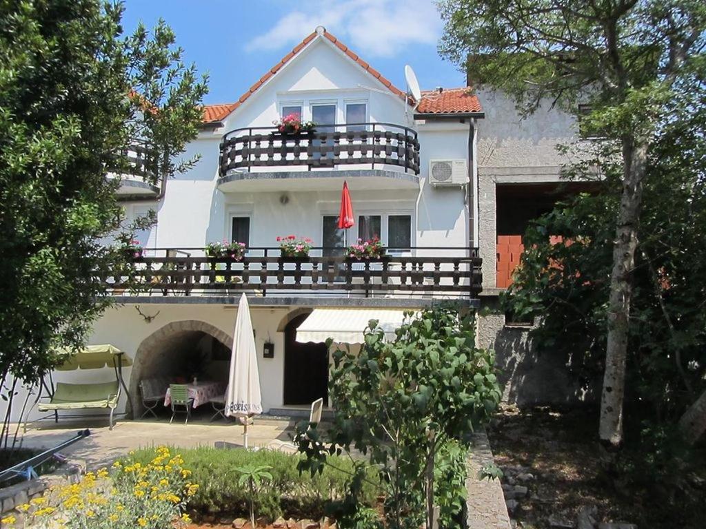 SršićiApartments Marijana的带阳台和遮阳伞的白色房屋