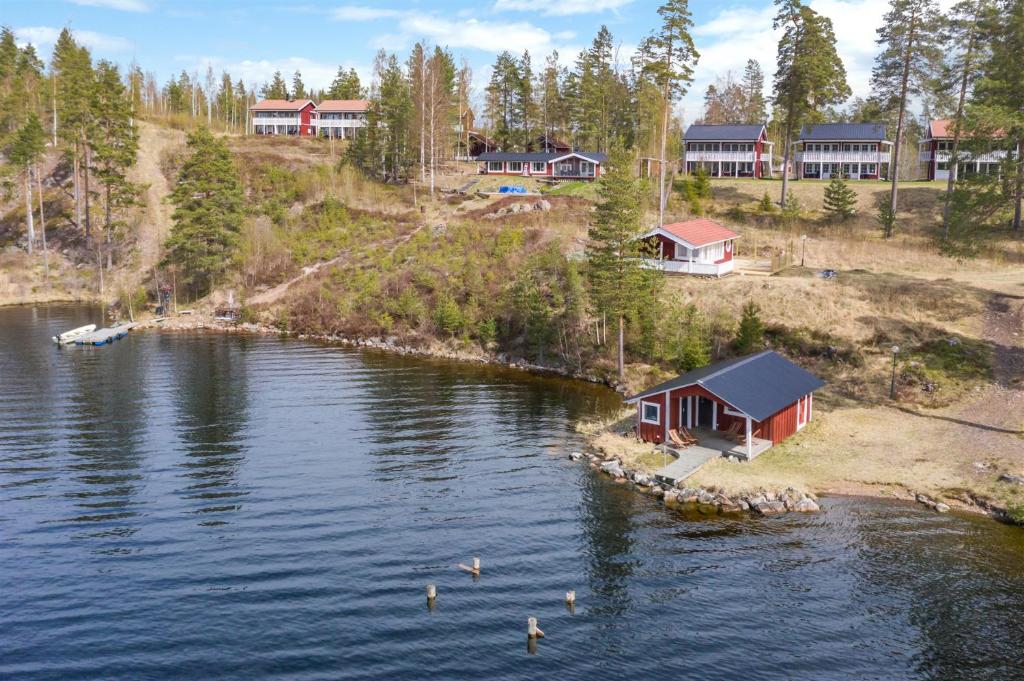 IdkerbergetRämsbyns Fritidsområde - Den perfekta platsen för avkoppling的湖岸上的房子,水中有鸭子