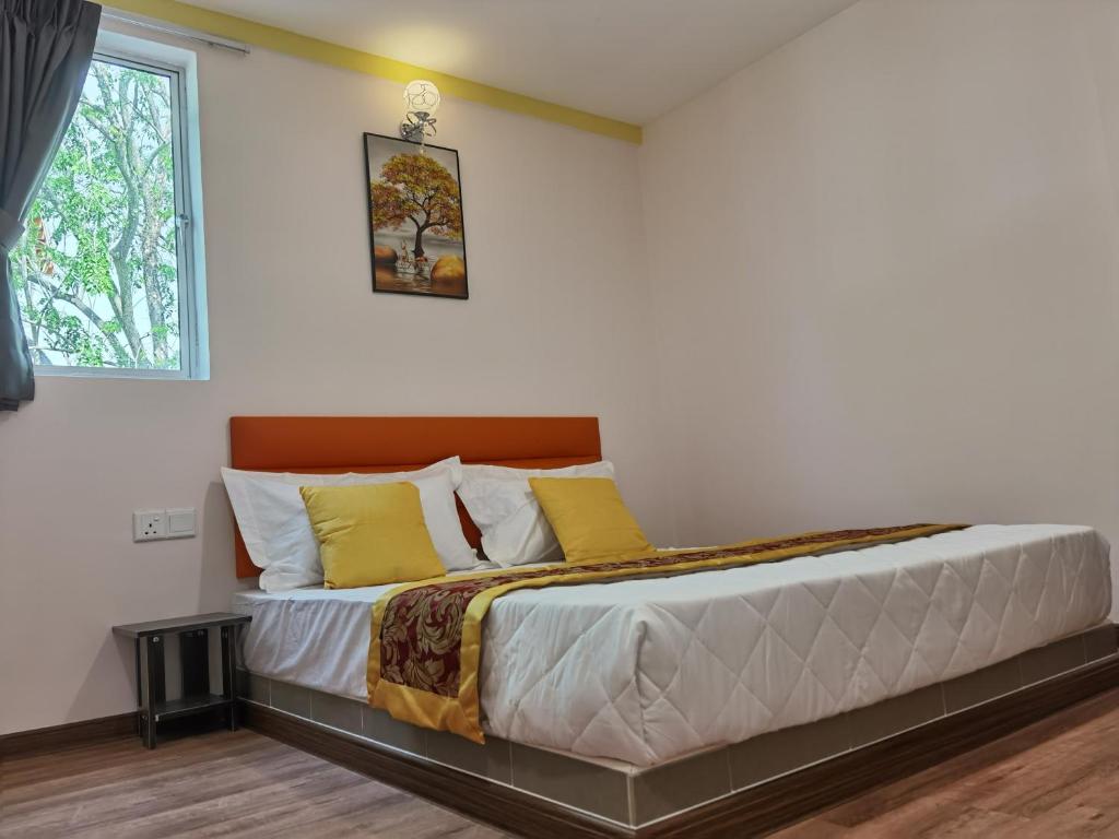 双溪大年MORNINGS HOTEL的一间卧室配有一张带黄色枕头的床和一扇窗户