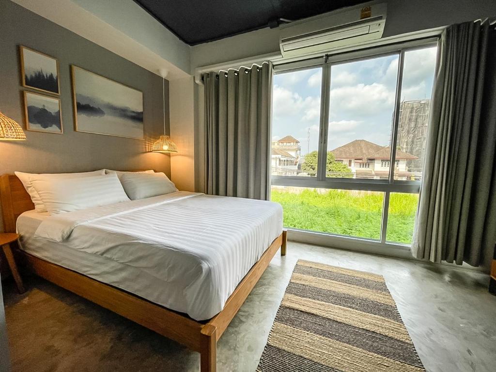 尖竹汶贝蒂加斯姆赤达布瑞旅馆的一间卧室设有一张床和一个大窗户