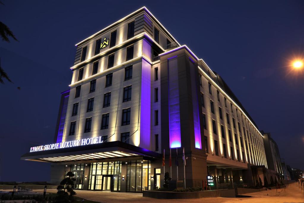 斯科普里Limak Skopje Luxury Hotel的建筑前方有紫色灯