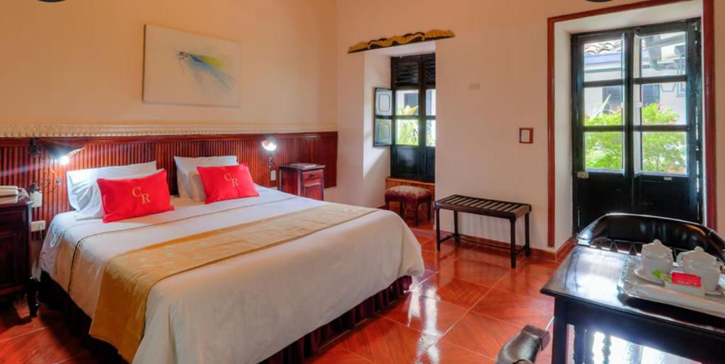 波帕扬卡米诺里奥波帕扬哥伦比亚酒店的一间卧室配有一张带红色枕头的大床