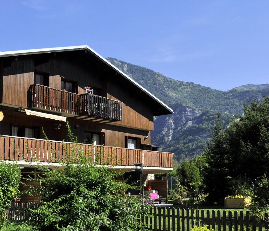 勒布罗伊斯Chalet la Cachette Cyclists & Skiers的一座木制建筑,设有阳台,享有山脉的背景
