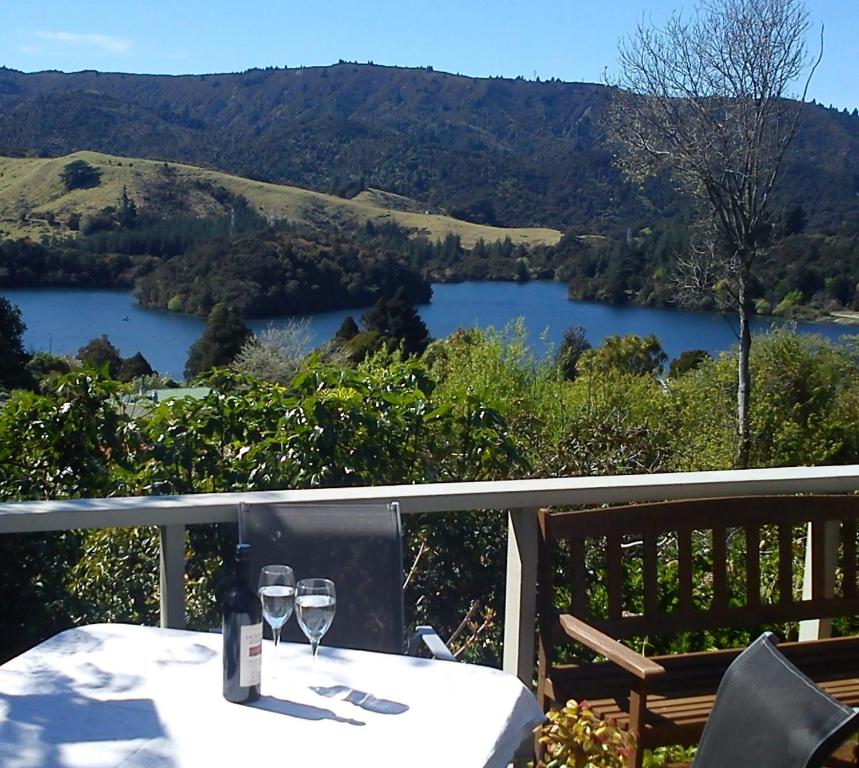 TuaiThe Tuai Suite Waikaremoana的湖景阳台的桌子和酒杯