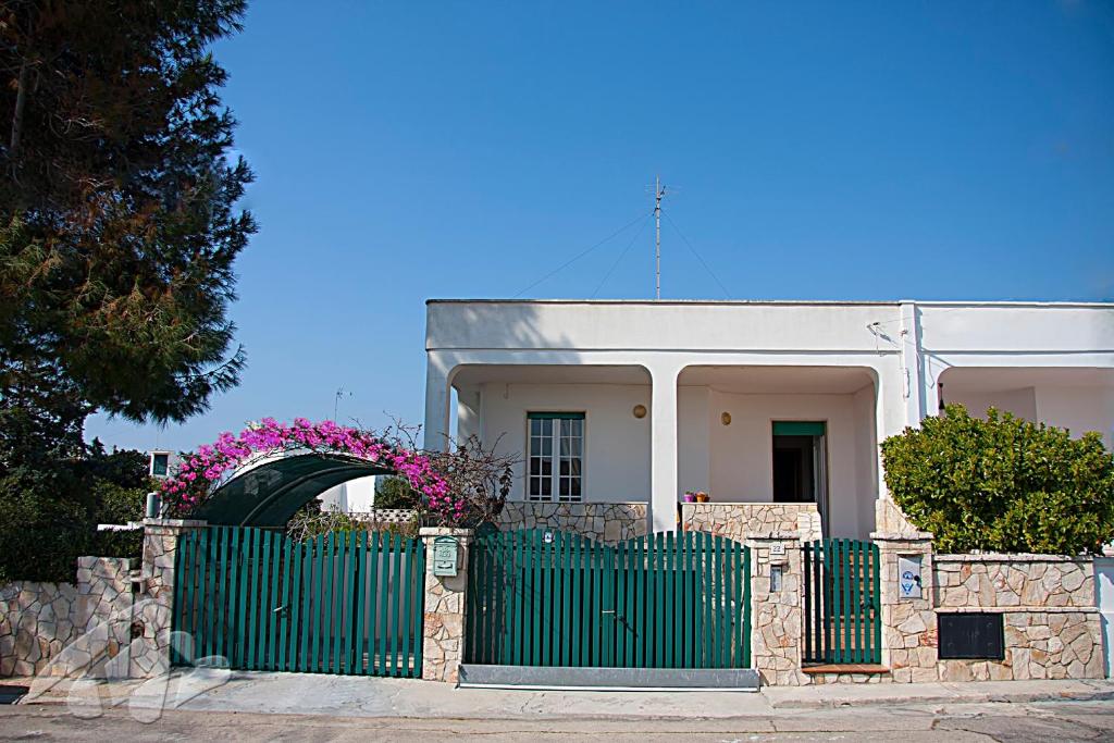 玛丽娜迪曼卡维萨Villetta Lungomare Gallipoli - Family House的白色房子前面的绿色围栏