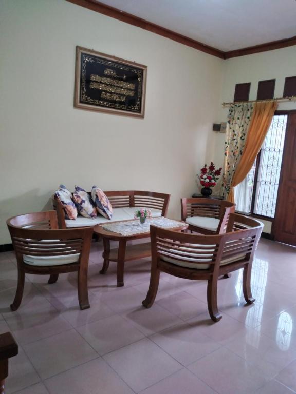 TanjungkarangRUMAH PAKSI HOMESTAY的客厅配有两把椅子和一张桌子