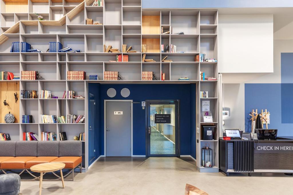 泰比Part-Time Home Täby的图书馆拥有蓝色的墙壁和书架