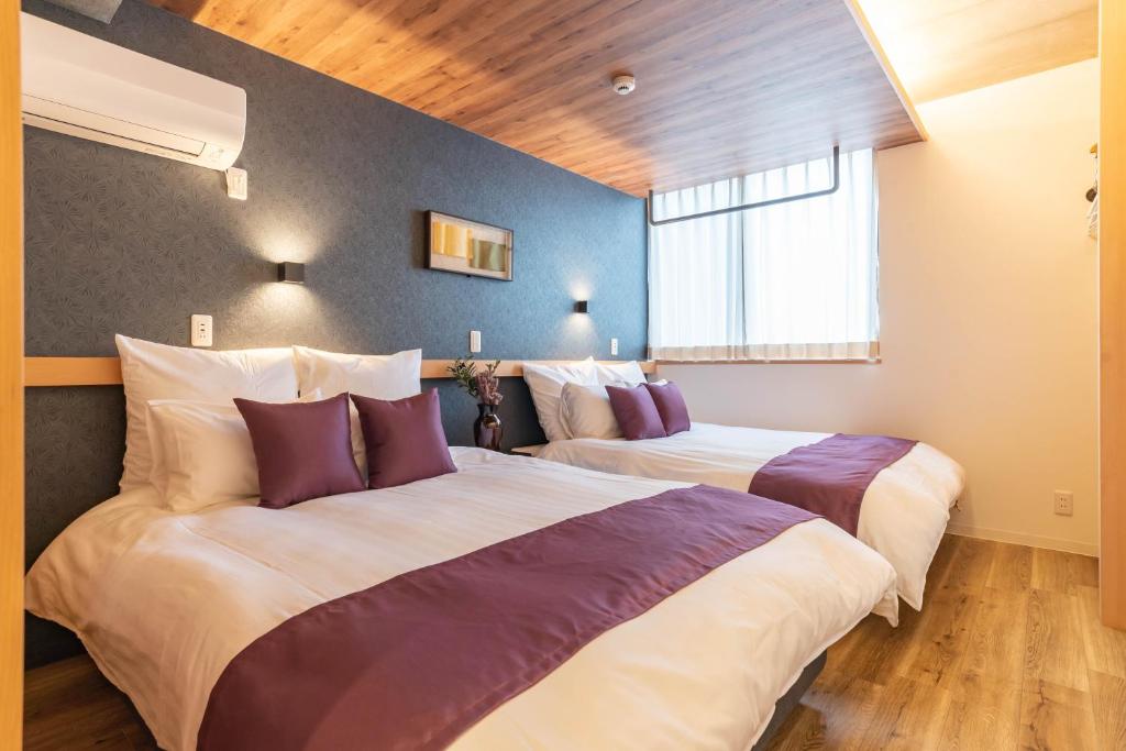 大阪Alla Scuderia Bijou Suites的酒店客房配有两张带紫色枕头的床