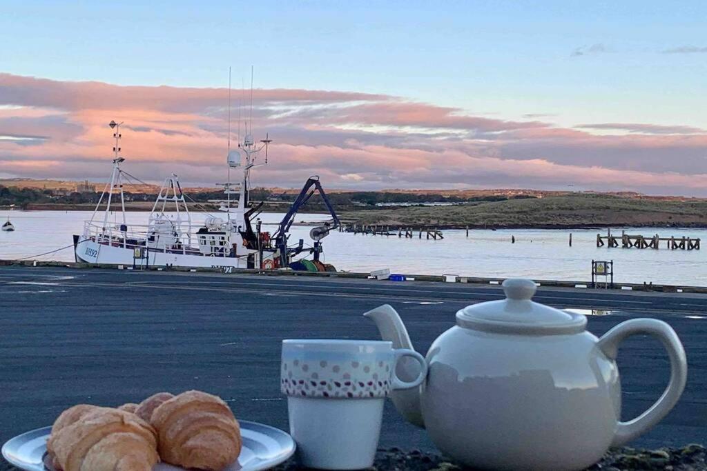 安布尔On The Harbour - unrivalled views of Amble's harbour and estuary的茶几,茶壶,羊角面包和小船