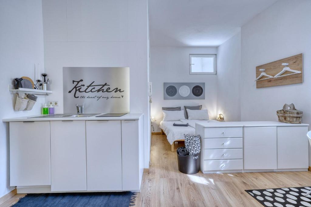 卡尔达罗Zentral gelegenes Apartment mit Garage und Garten的白色的客房设有水槽和一张床