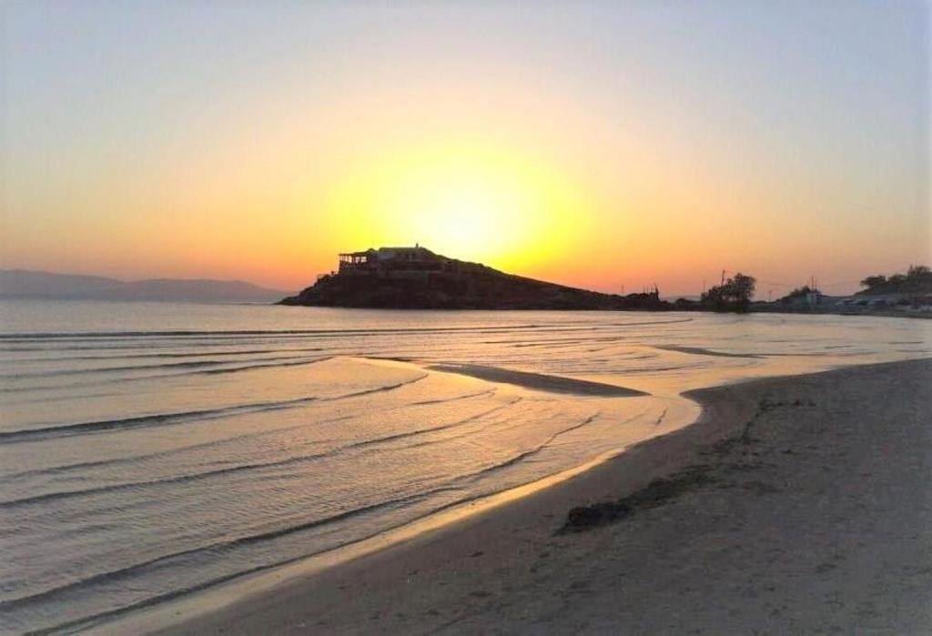 纳克索乔拉Mama's Rooms - Eurostudiosnaxos的岛上的别墅在海滩上日落