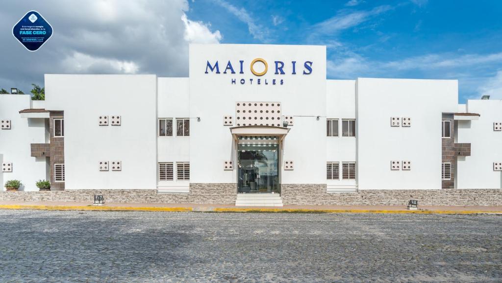 瓜达拉哈拉Hotel Maioris Guadalajara的一座白色的建筑,上面标有读摩利诺斯酒店的标志