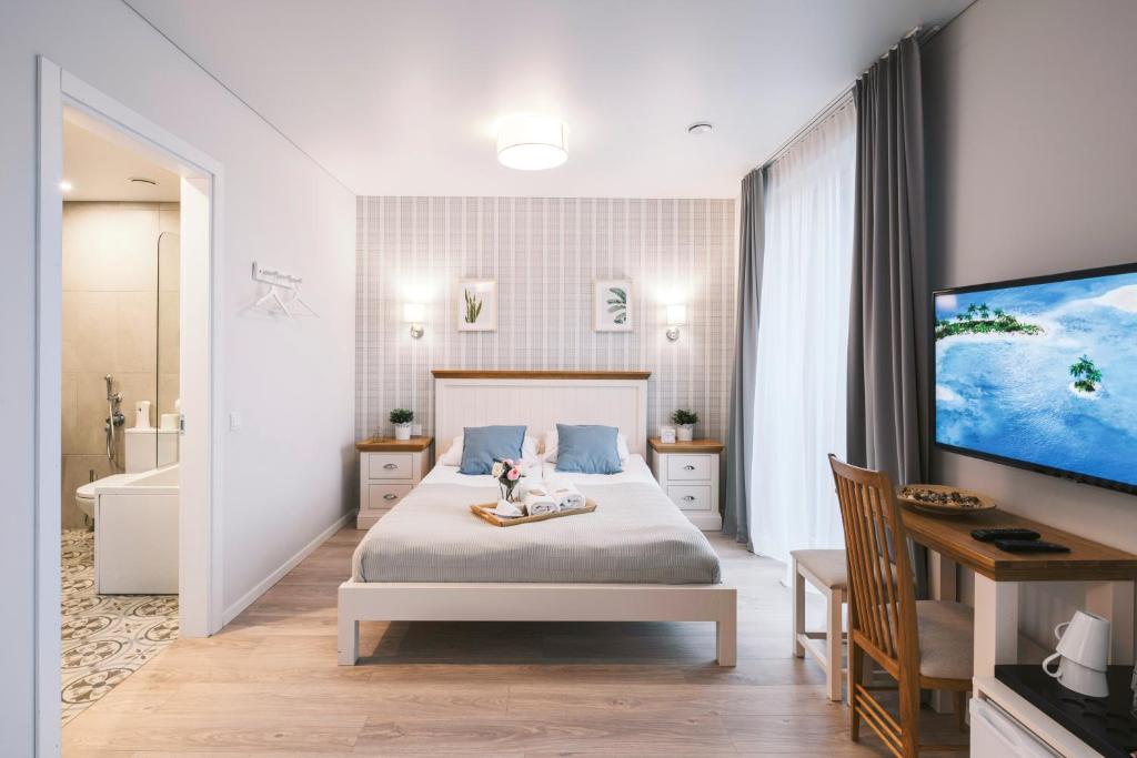 维尔纽斯Real House Jasinskio WEB-APP SELF CHECK-IN的一间卧室配有一张床、一个浴缸和一台电视。